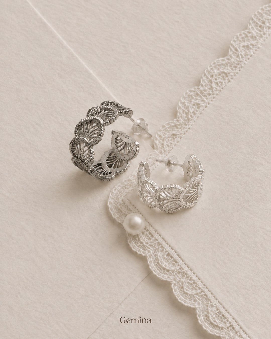 Two sterling silver lace hoop earrings on lace, one tarnished and one polished bright
