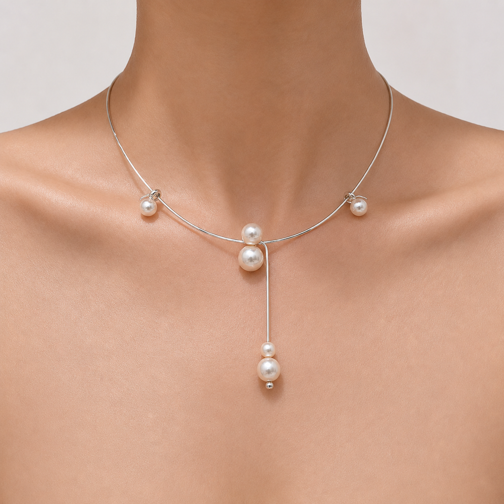 Gemina Colette rigid silver collar necklace with freely sliding pearls, worn at the collarbone