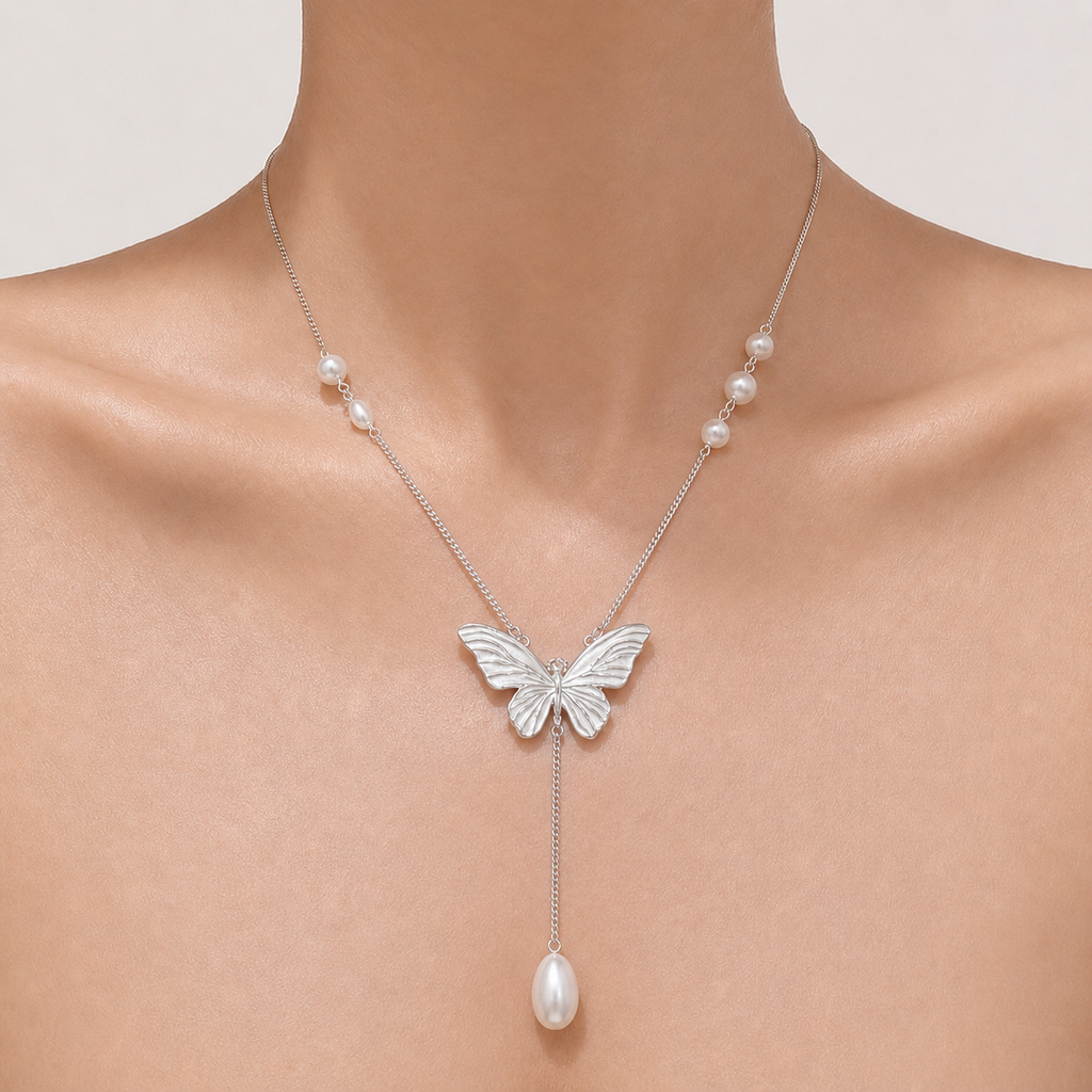 Gemina Margot enamel butterfly necklace with a pearl drop, worn at the collarbone