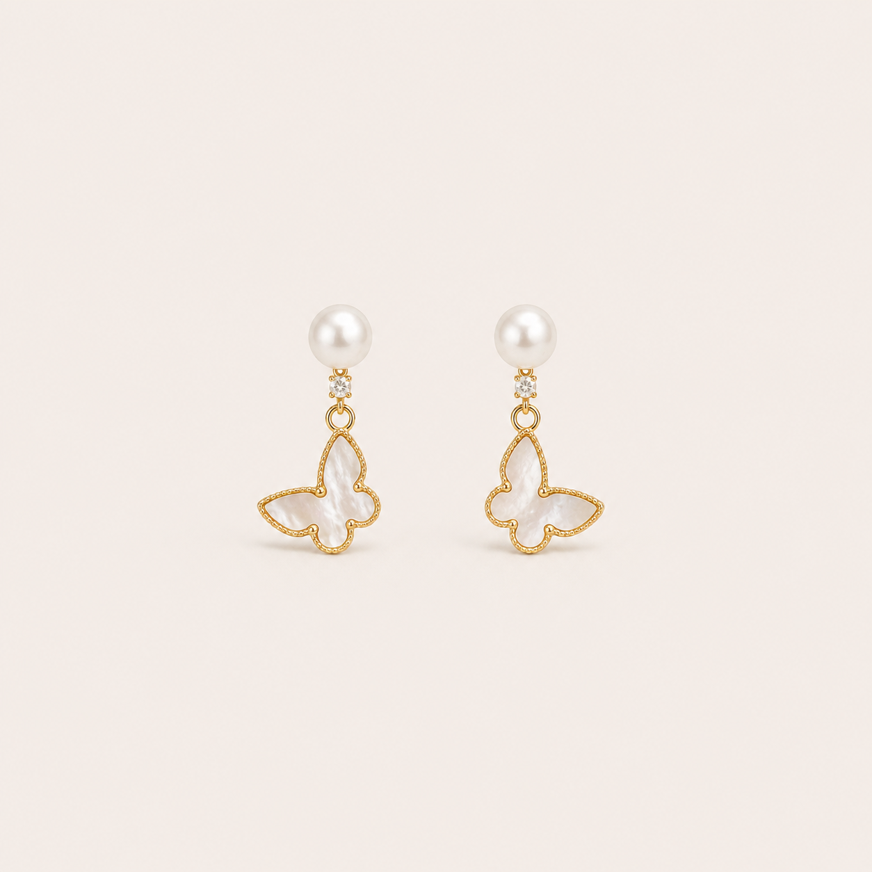 Gemina Marine gold butterfly earrings with natural white shell wings and a freshwater pearl