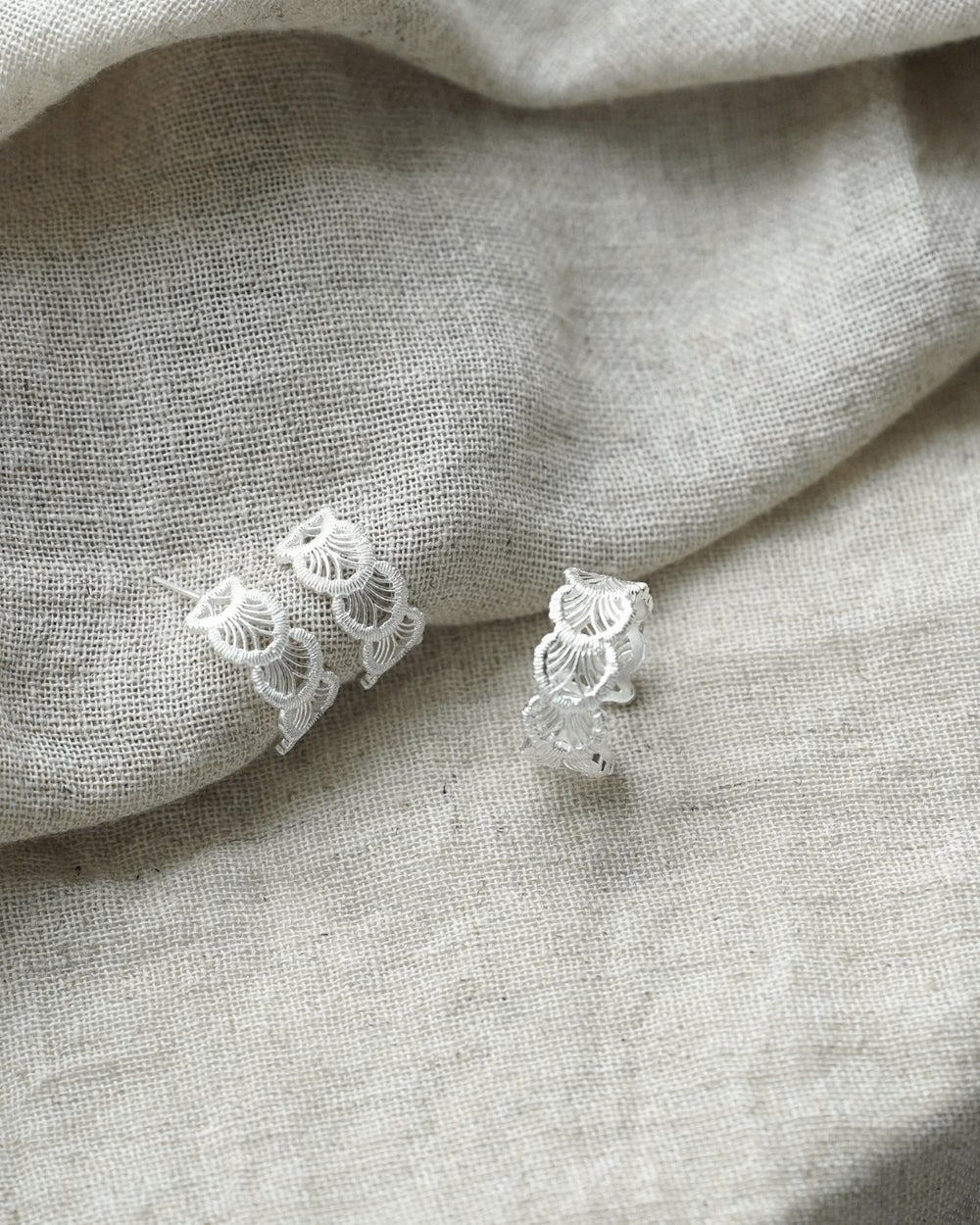 Sterling silver lace texture earrings and lace ring on linen